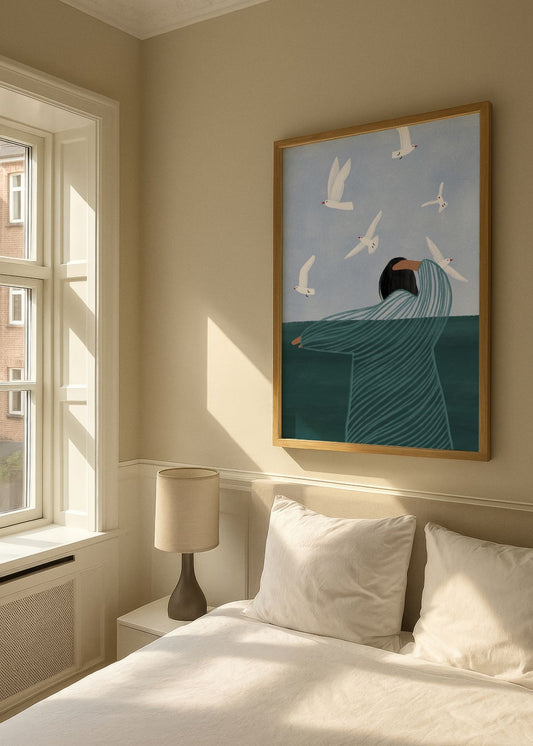 Seaside Serenity poster in an oak frame hanging above a bed in a bright Scandinavian bedroom, with soft natural sunlight, neutral tones, and a peaceful seaside illustration.