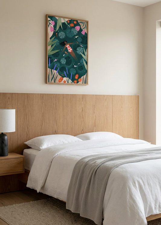 Wild Swimming by Bea Muller poster in oak frame styled above bed in calm Scandinavian bedroom with wooden headboard and neutral tones.