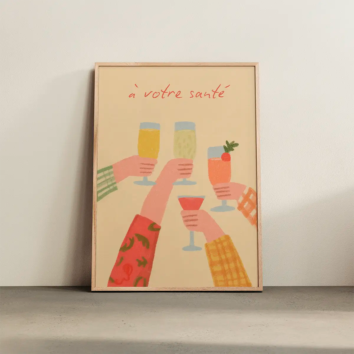 Poster with colourful hands raising glasses in a toast, framed in light oak and leaning against a white wall, soft natural light creating a warm Scandinavian atmosphere.