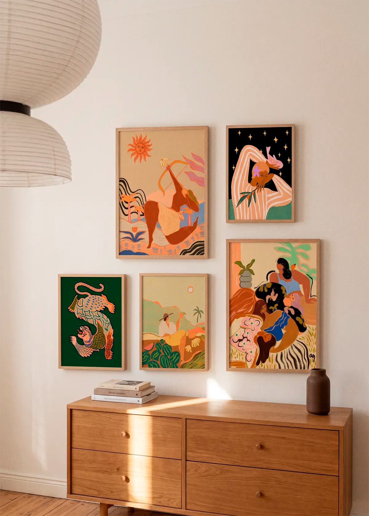 Bow And Arrow by Arty Guava shown as part of a curated gallery wall with five Arty Guava posters in warm, colourful tones above a wooden dresser in a Scandinavian interior.
