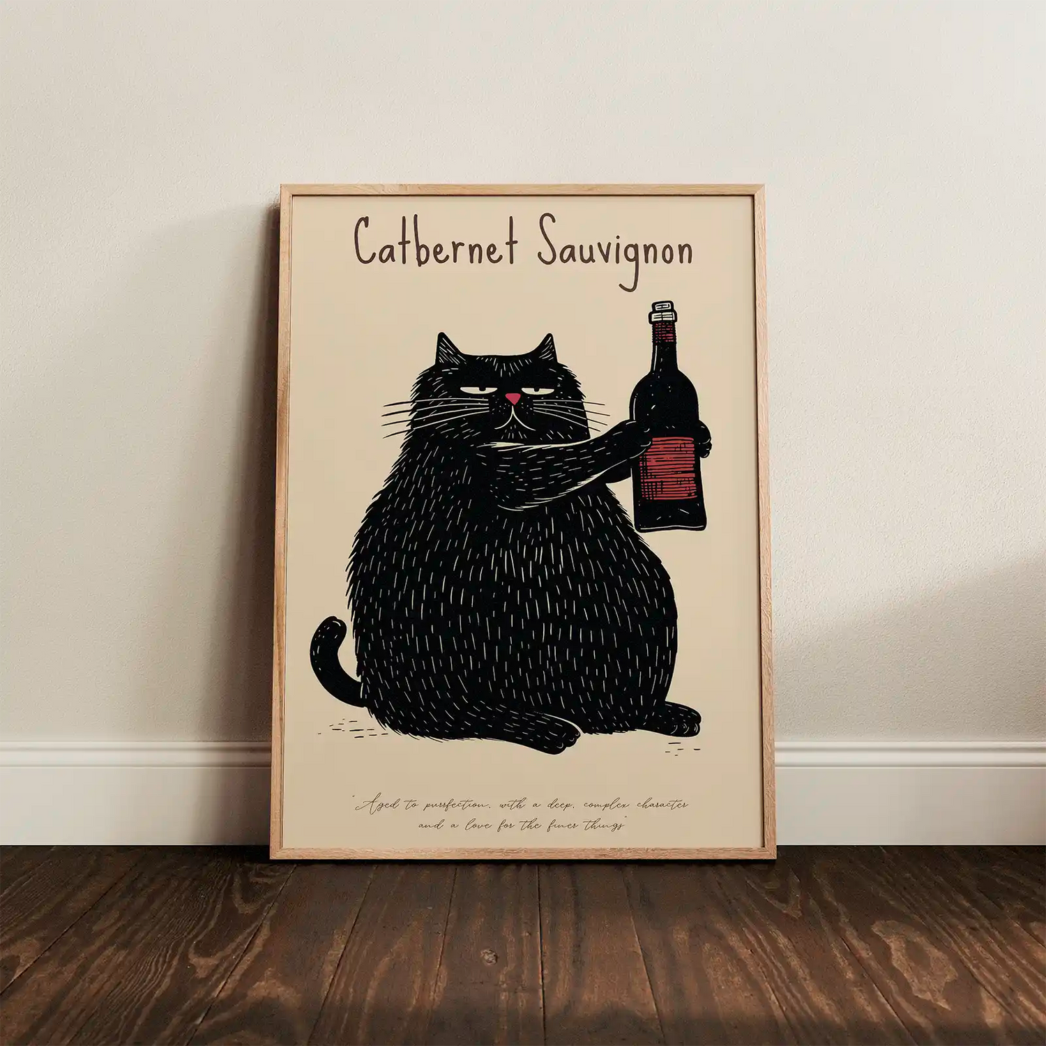 Framed Catbernet Sauvignon cat poster leaning against a white wall on a dark wooden floor, illuminated by gentle natural lighting.