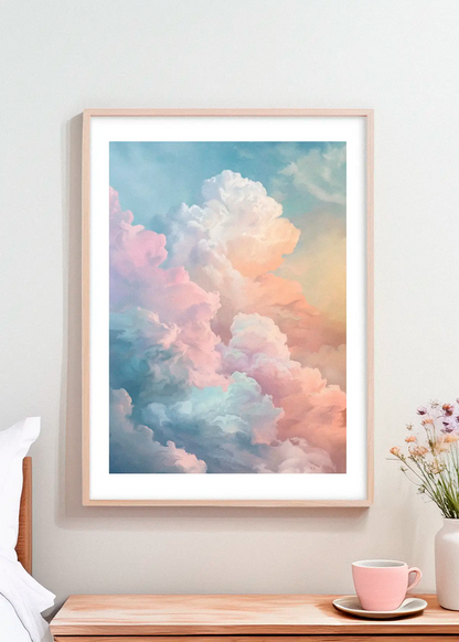 Framed pastel cloud poster hanging above a wooden bedside table with a pink teacup and small flowers in soft Scandinavian daylight.