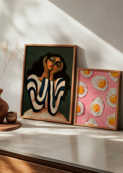 Colorful poster duo featuring "Daisy" and "Fried," combining abstract portrait art with a playful fried egg motif on pink, perfect for a bold gallery wall.