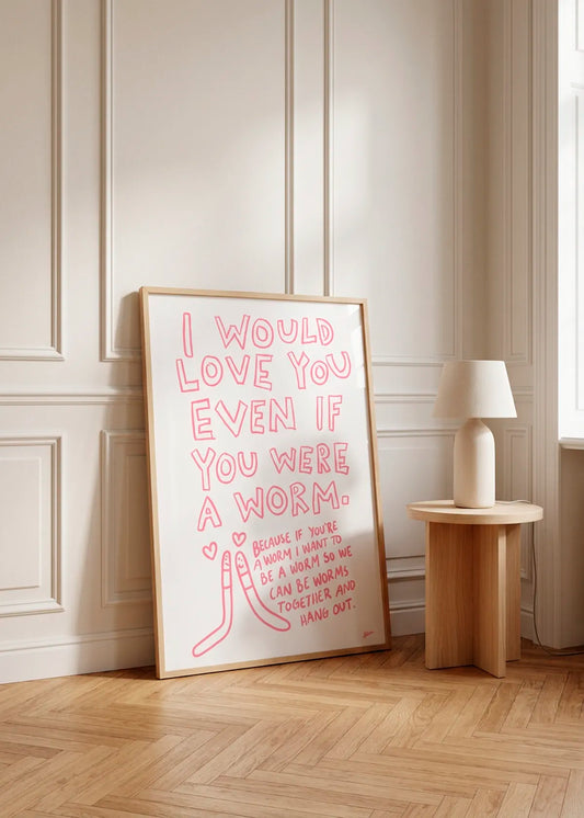 Even If You Were A Worm by Athene Fritsch – framed pink typographic love poster with playful worm illustrations, styled against a soft neutral wall with natural wood furniture.