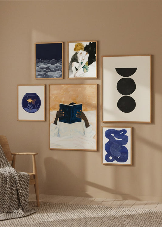 Large curated gallery wall with Scandinavian posters in blue, beige and black tones styled on a warm beige wall.