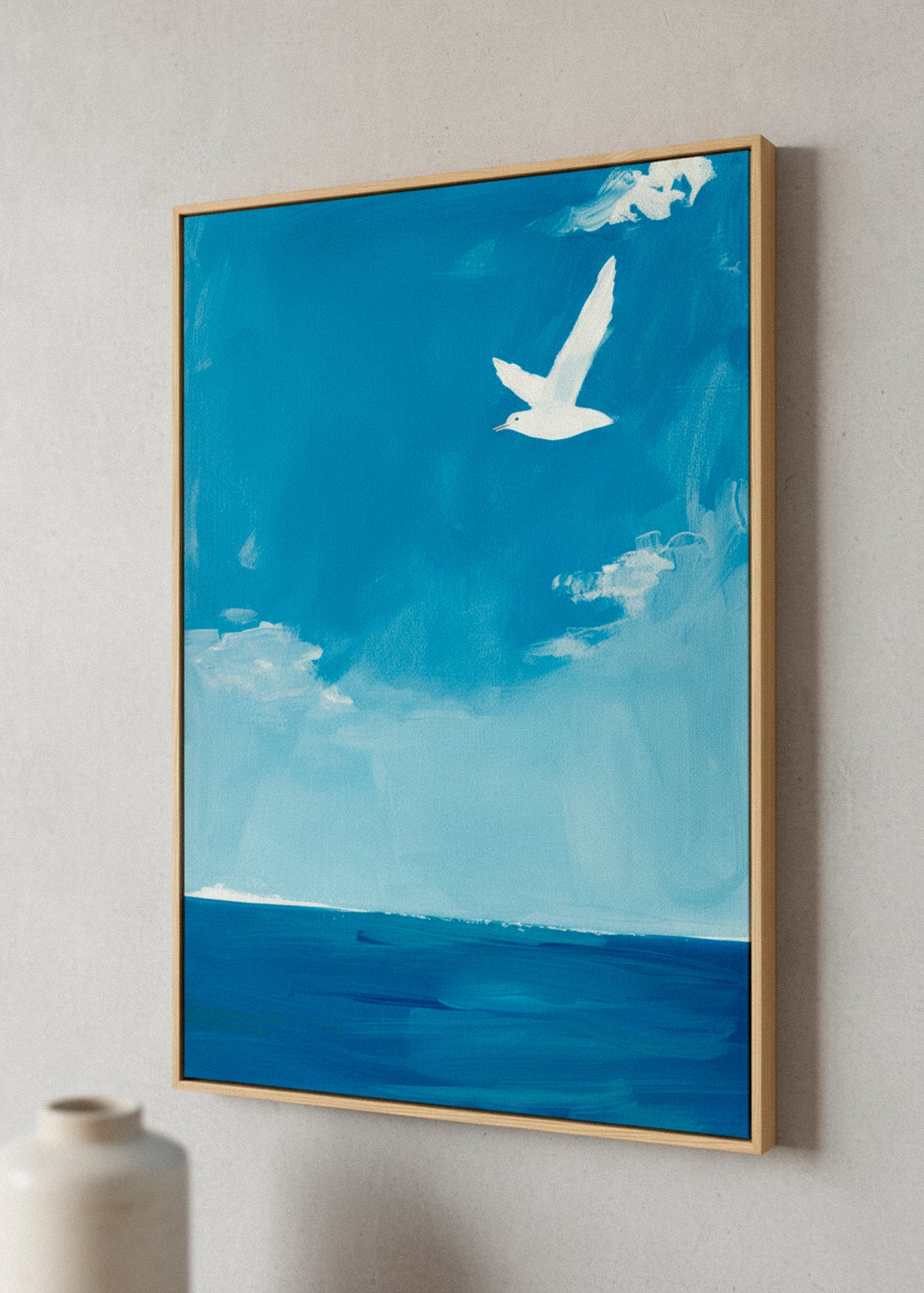 “Ocean” canvas print hanging in a sunlit room with natural textures and plants, evoking seaside tranquility and Nordic serenity.