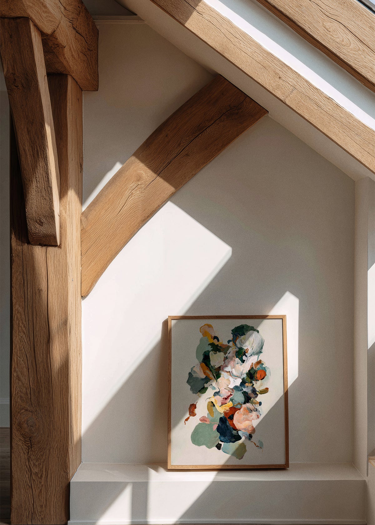 Farverig abstrakt plakat Pelate fra Hello Poster, placeret på gulv i sollys omgivet af rustikke træbjælker og moderne nordisk interiør.