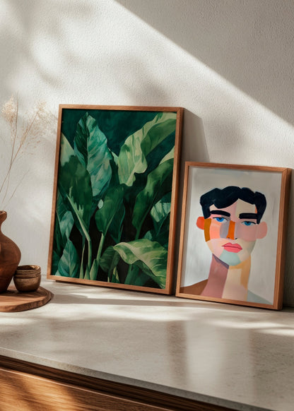 Botanical 'Plant' poster next to the abstract portrait 'Male', styled on a modern shelf with earthy tones.