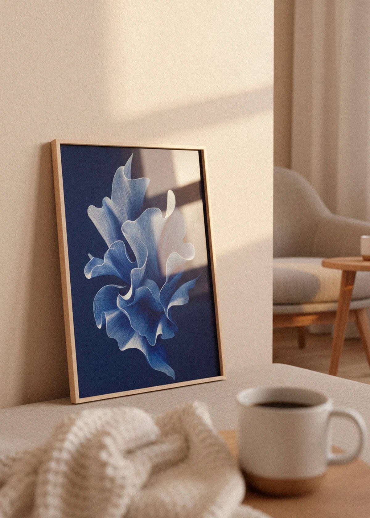 Shape No. 80 art print in oak frame leaning against a beige wall in a cozy Scandinavian living room with warm sunlight and a cup of coffee in the foreground.