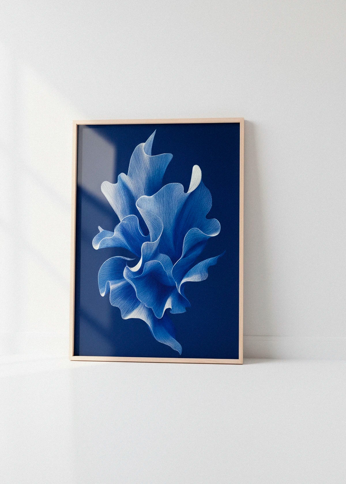 Shape No. 80 art print in an oak frame leaning against a bright white wall with soft natural light creating subtle window reflections.