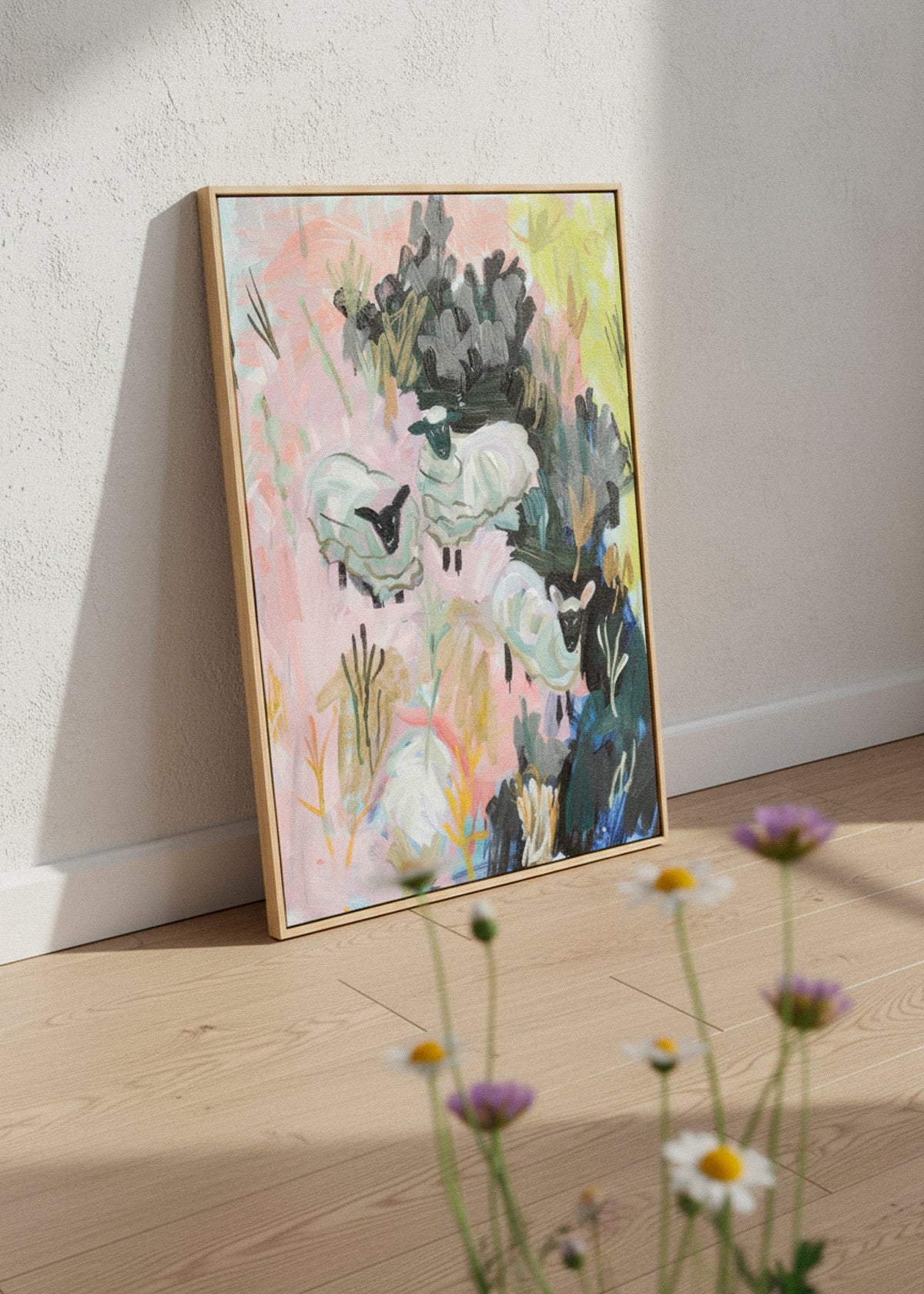 “Sheep Farm” canvas print showing abstract sheep in a colorful field of pink, green, and yellow tones. Displayed in a calm Scandinavian room with soft daylight and neutral decor.