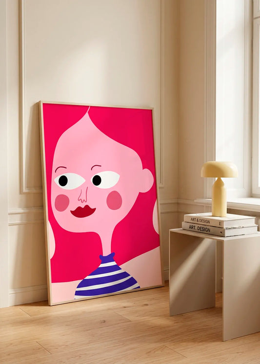 Whimsical Stripes by Athene Fritsch – framed pink and blue illustrative portrait poster styled in a bright neutral interior with wooden flooring and a small side table.