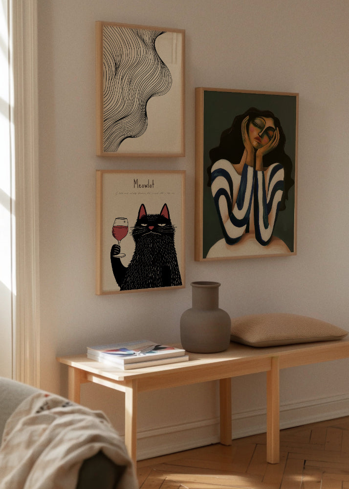 Tate, Daisy & Meowlot – Artistic Corner Display
Stylish corner wall with three prints: abstract flowing black lines on beige ("Tate"), a black cat with a wine glass and deadpan expression ("Meowlot"), and a dreamy portrait of a woman resting her head in her hands ("Daisy").